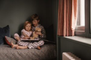 Two children reading a story book in Stanwell House room